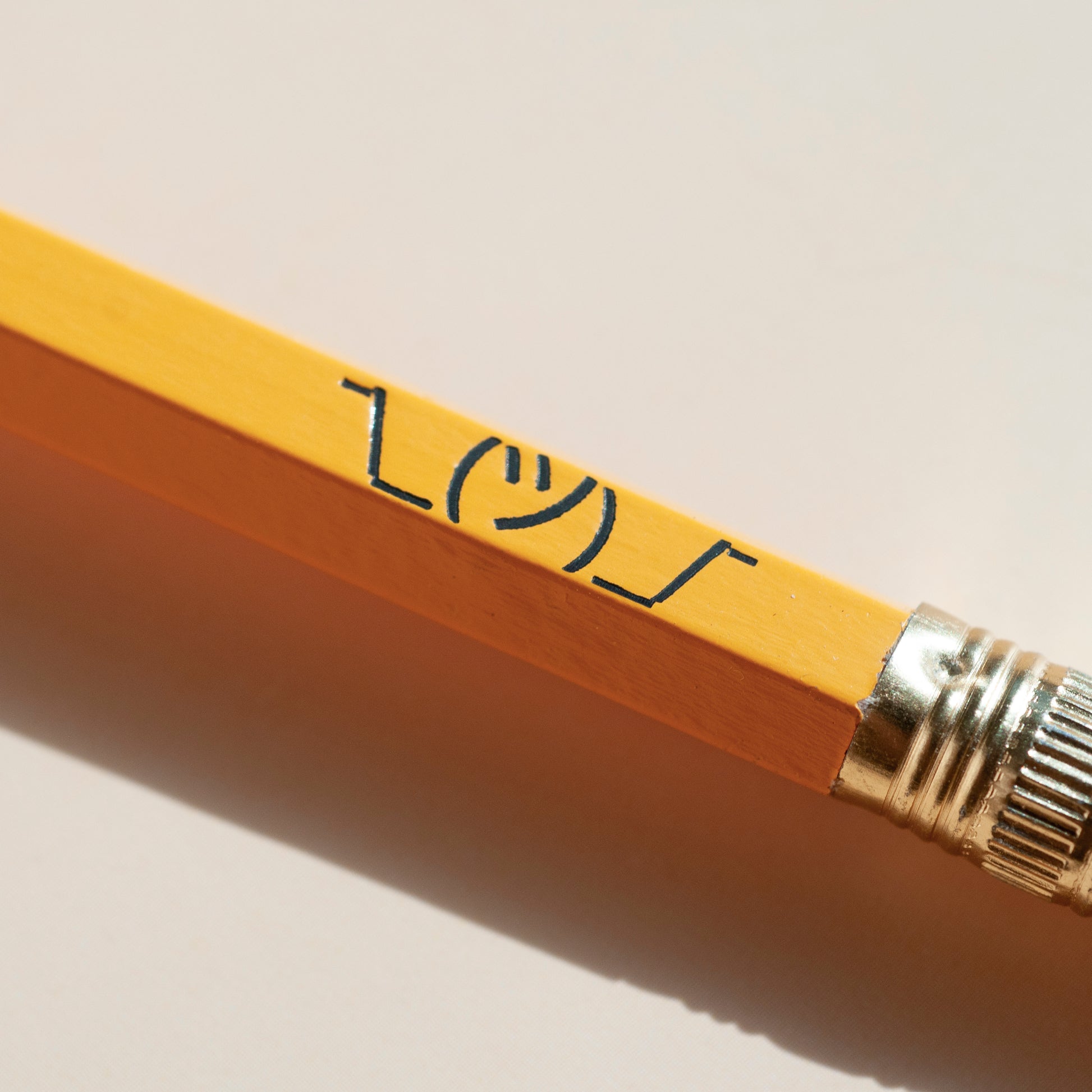 ASCII shrug meme, ¯\_(ツ)_/¯ , stamped onto yellow school pencil