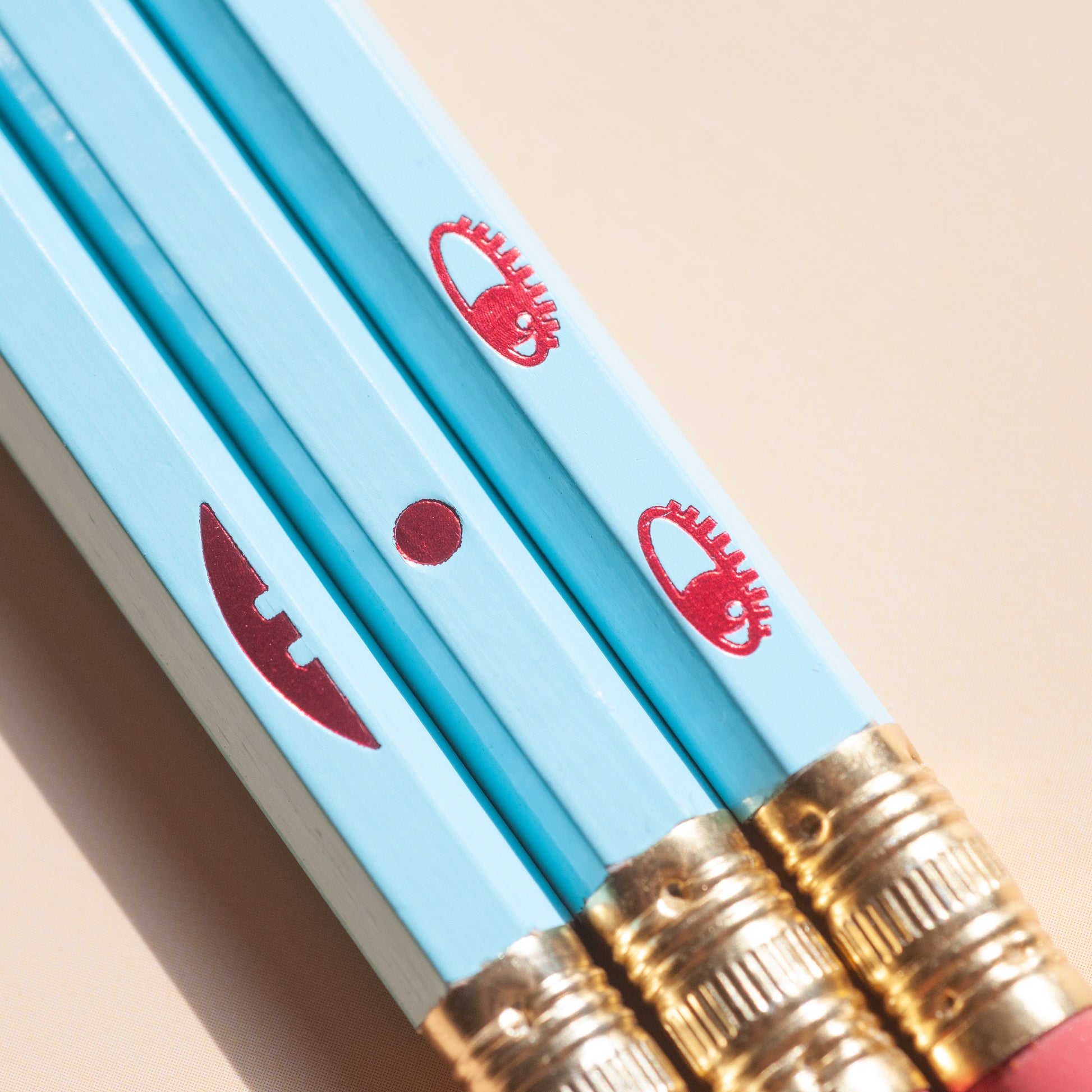 Macro smiling face pencil set. Happy on the front and sad on the back. Hand-stamped using hot-foils on wooden hexagonal pencils