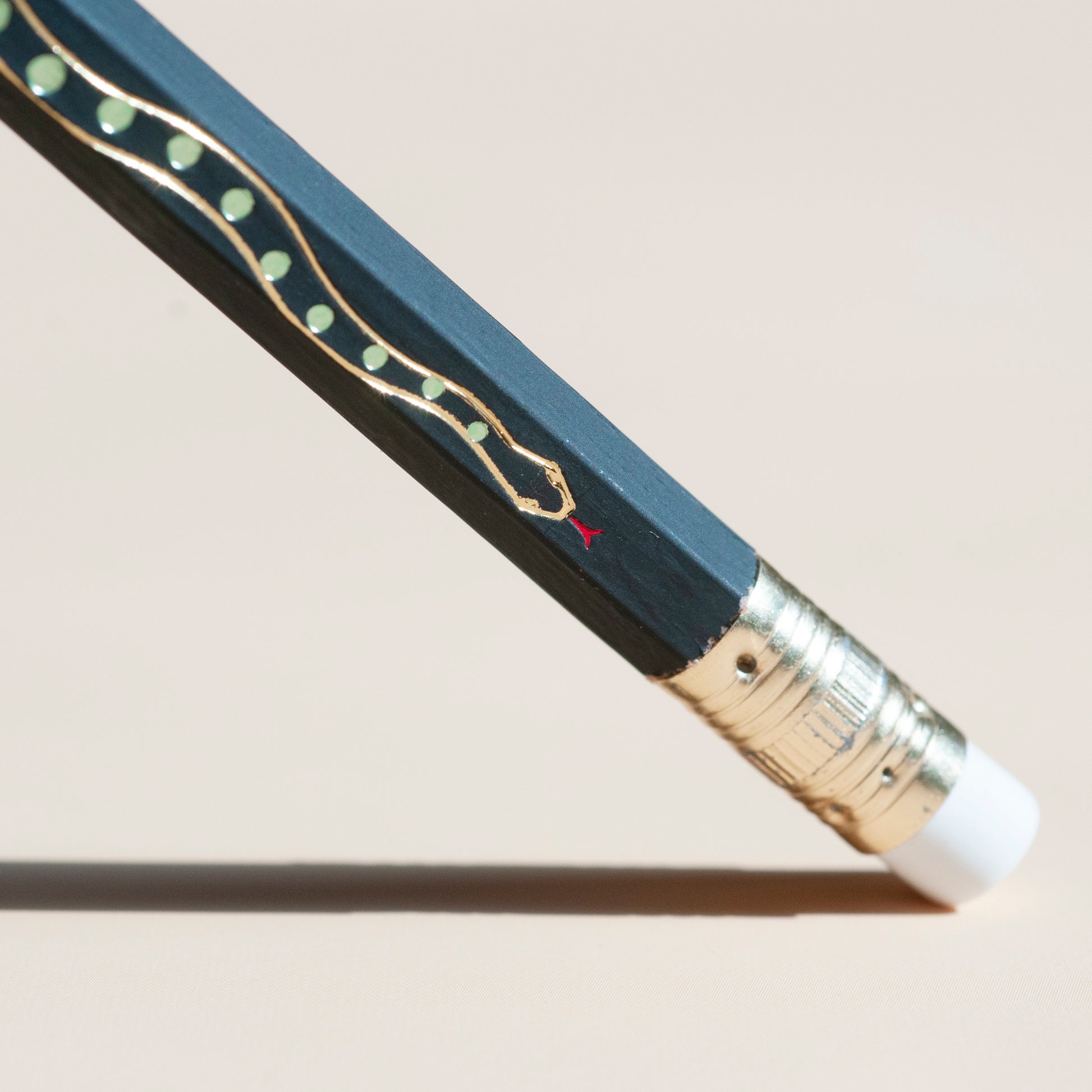 Macro gold metallic snake hot-foil stamped on pencil