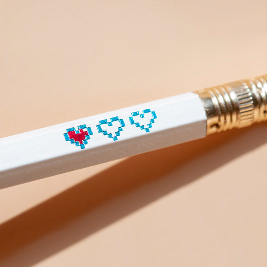 Macro shot of hand-stamped pencil set with pixel heart containers blue and red