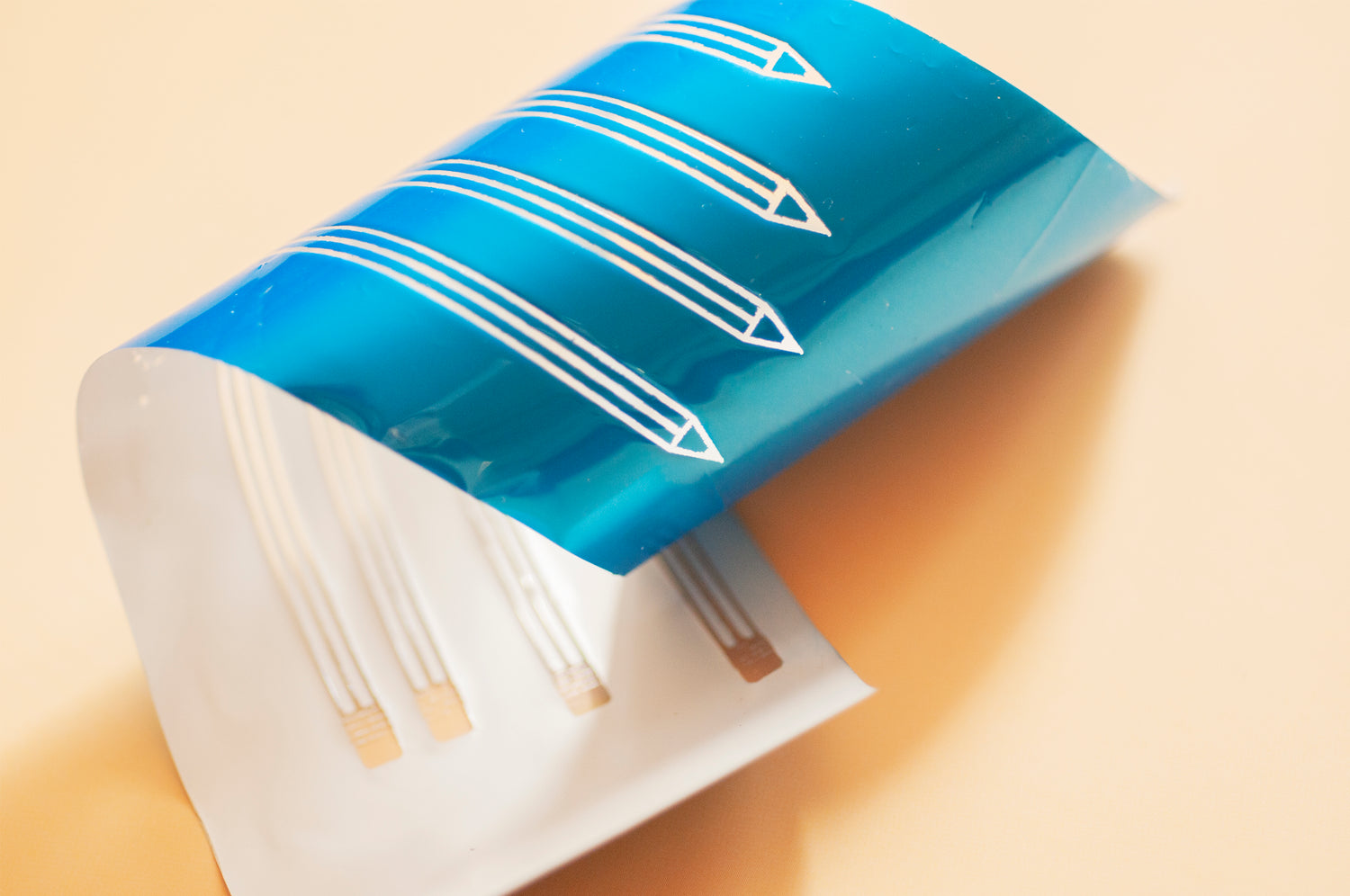 A piece of used blue metallic hot foil where the pencil design has been stamped away and is see through