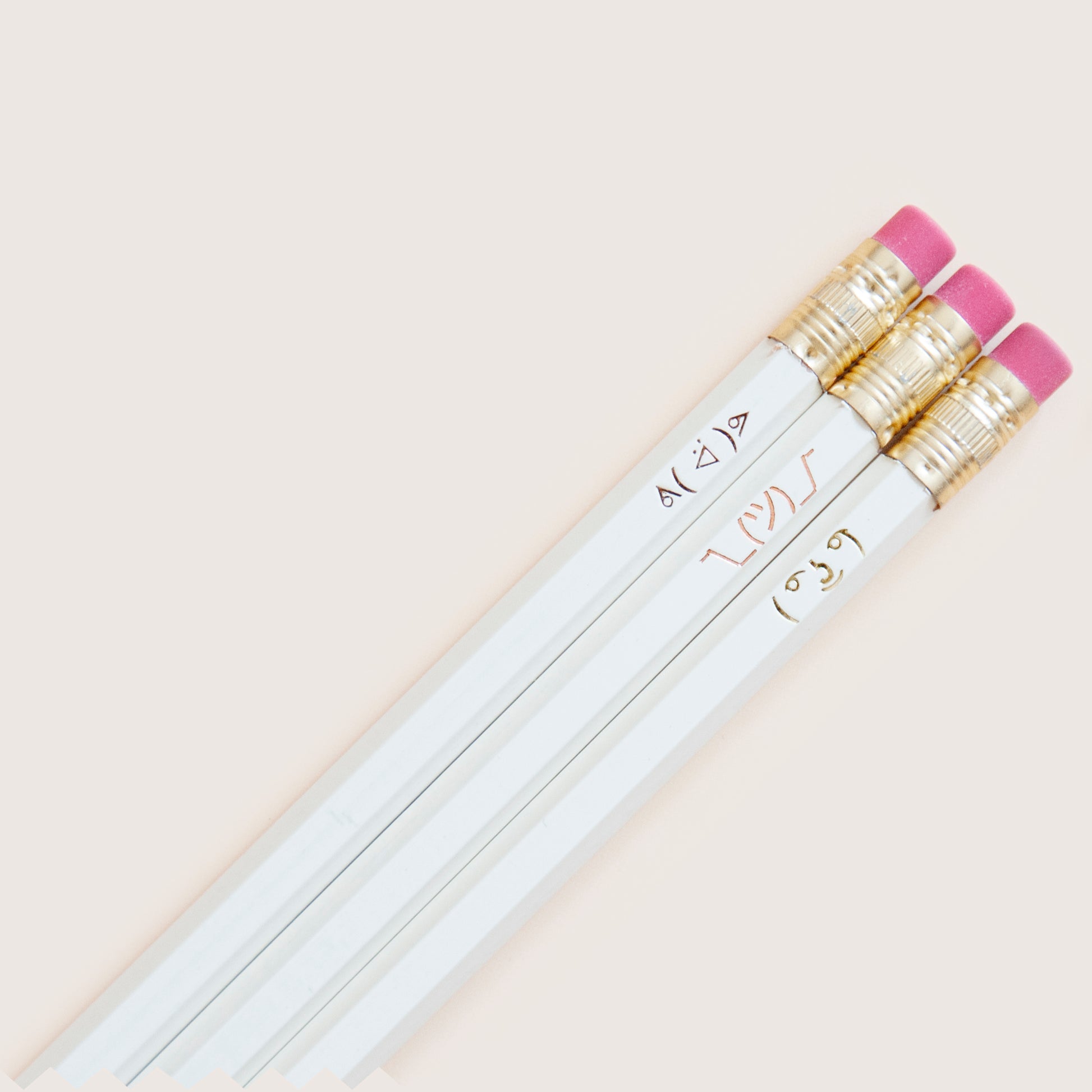 Handmade hot-foil stamped pencils with ASCII face designs in metallic foils