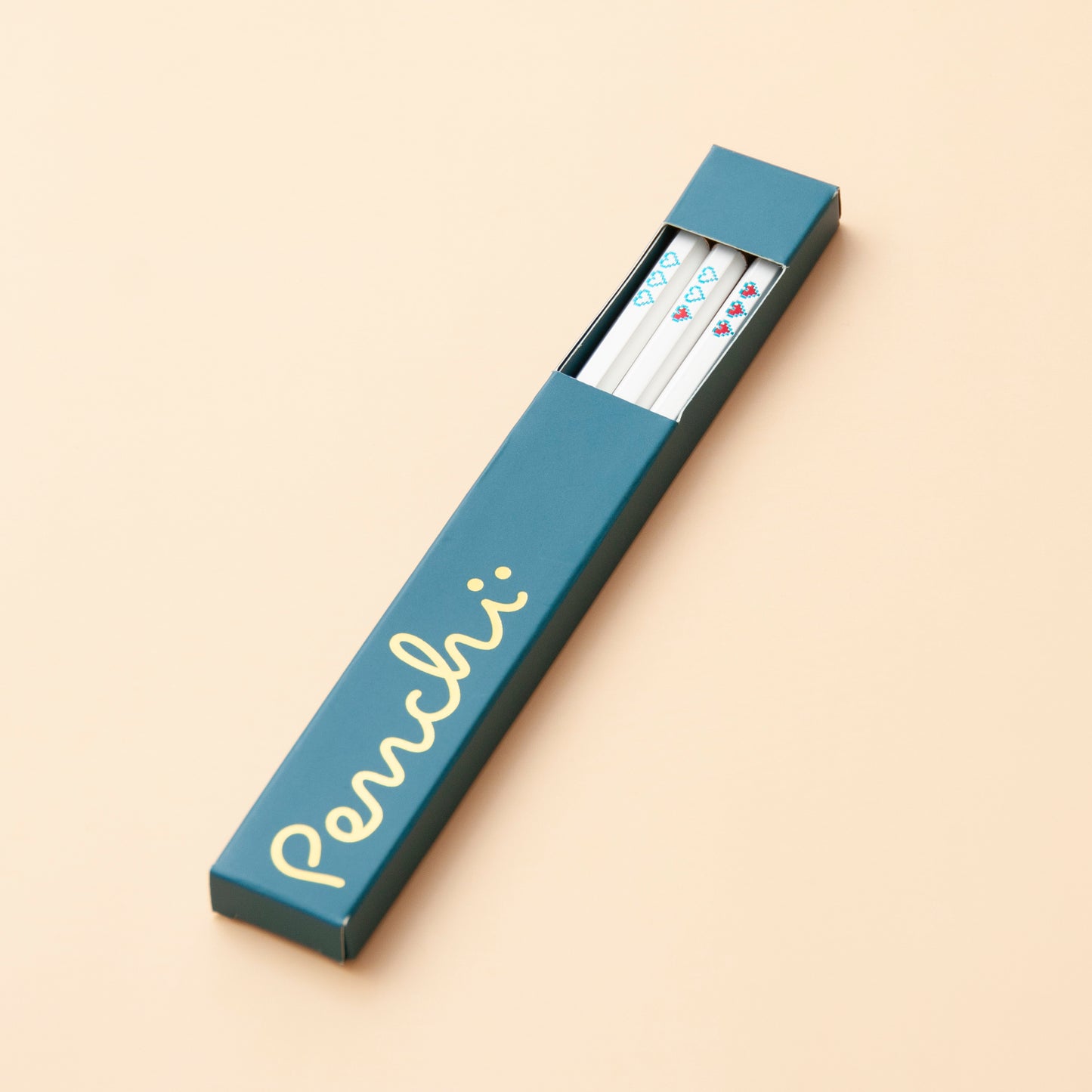 Handmade foil-stamped white pencils with pixelated heart containers, packaged in box with window and gold foil