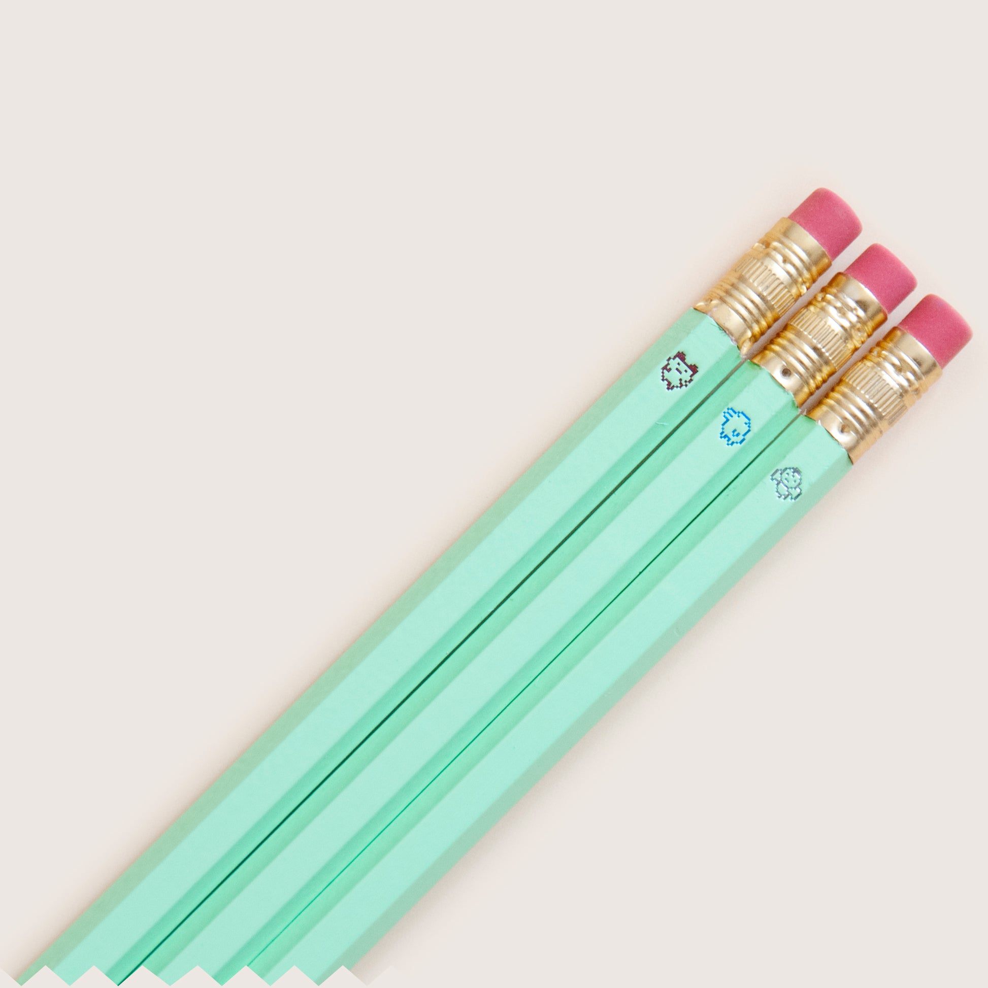 Original 90s Tamagotchi inspired pencil set featuring tiny pixel sprites, hand-stamped on wooden pencils, mint green