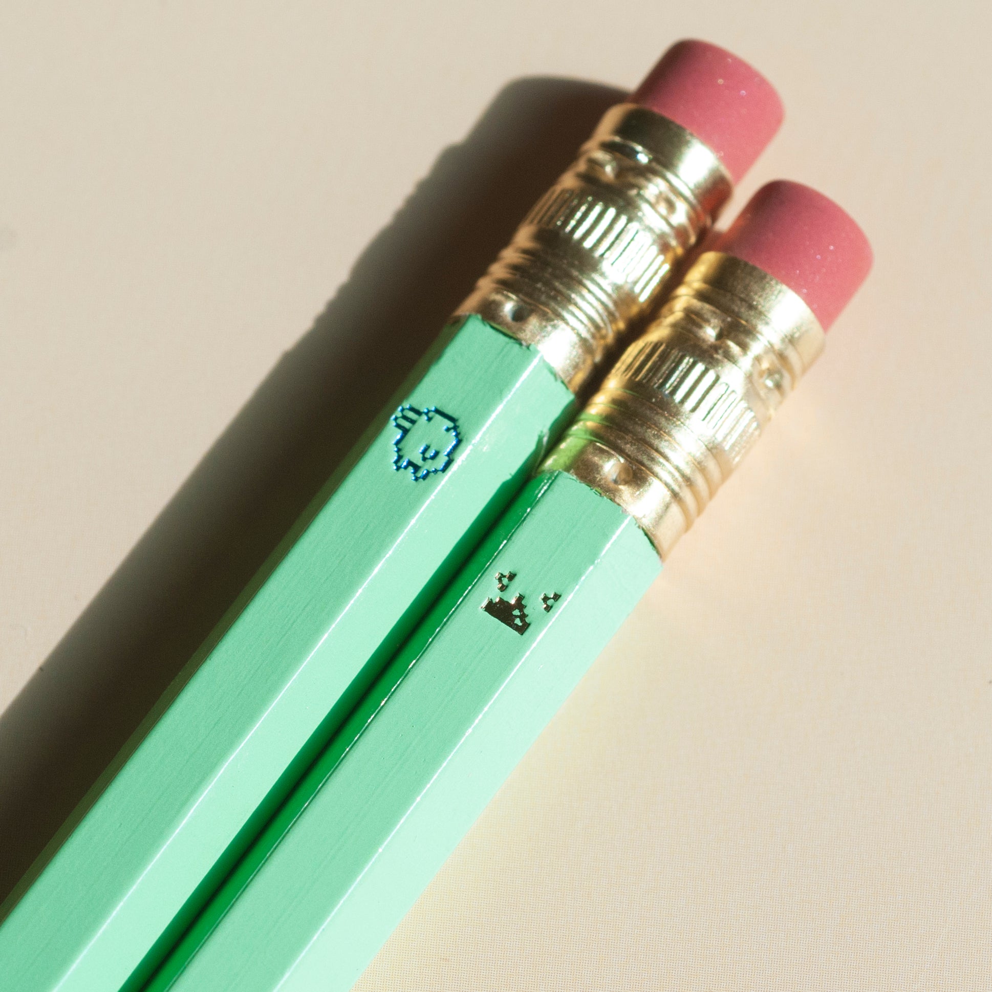 Macro shot of Tamagotchi inspired pencils featuring pixel sprites and tiny poop, hot-foil stamped by hand in Toronto