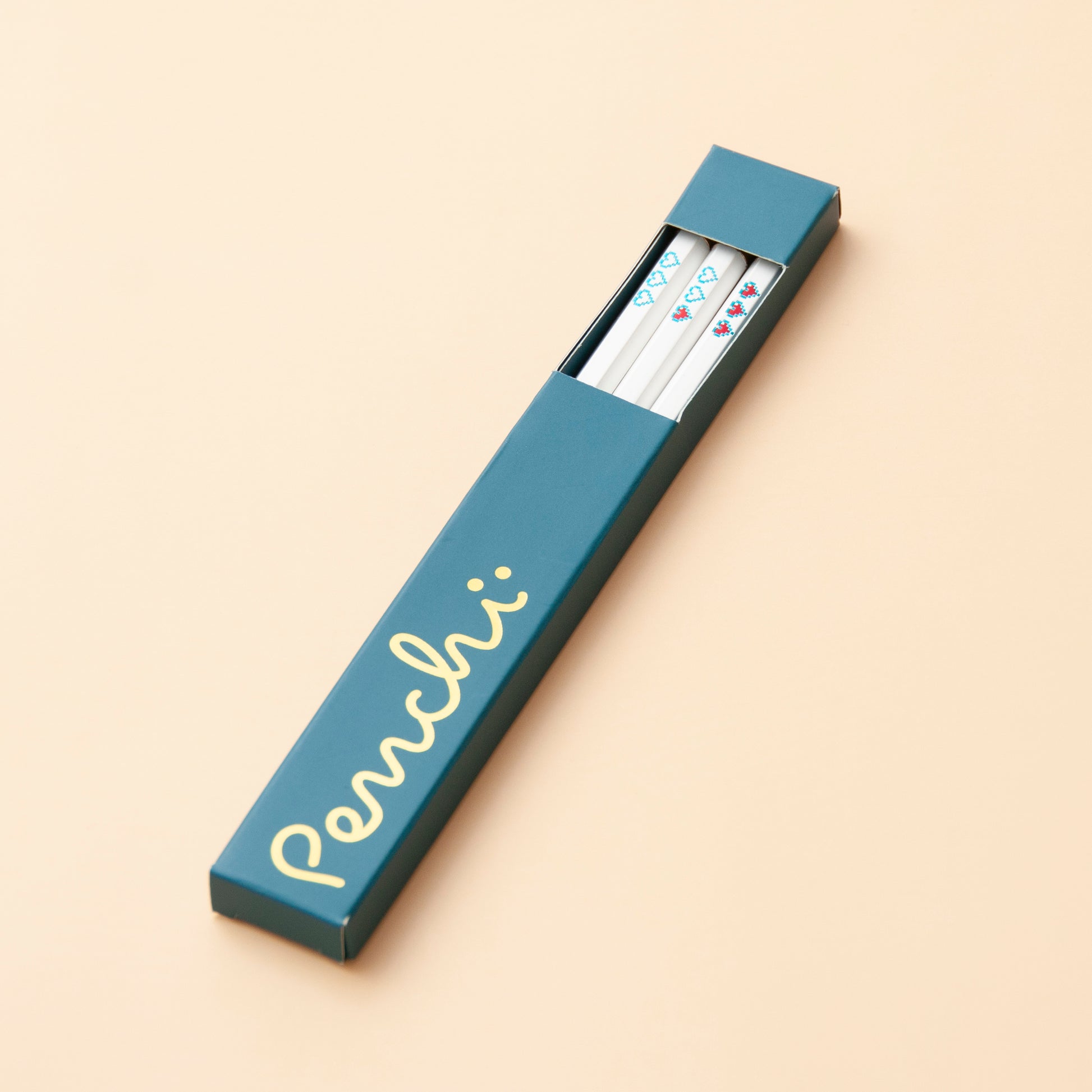 Handmade foil-stamped white pencils with pixelated heart containers, packaged in box with window and gold foil